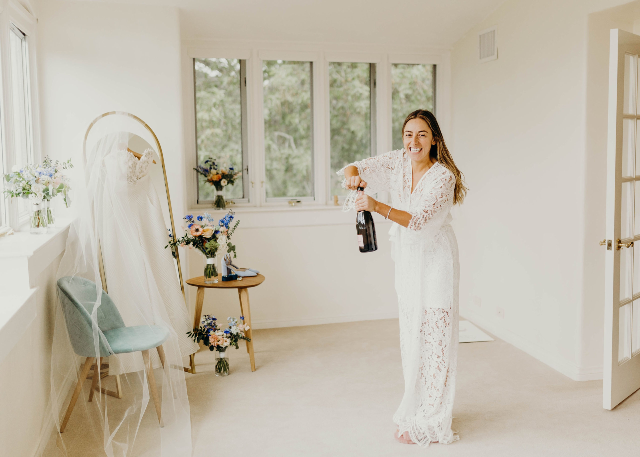 Bride popping champagne in getting ready suite King Gillette Ranch Calabasas Wedding